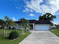 Charming single-story home with a well-manicured lawn and a two-car garage on a sunny day at 1025 Sullivan St, Deltona, FL 32725
