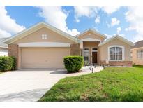 Charming single-story home featuring a well-maintained lawn and a two-car garage at 1021 Jaybee Ave, Davenport, FL 33897