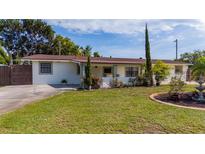 Charming single-story home featuring a well-manicured front yard with mature trees and beautiful landscaping at 1105 Arrowsmith Ave, Orlando, FL 32809