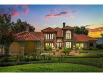 Stunning Mediterranean-style home boasting a red tile roof, lush landscaping, and a brick-paved driveway at 1351 N Classic Ct, Longwood, FL 32779