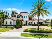 Stunning Mediterranean-style home with lush landscaping, circular driveway, and a grand palm tree at 1517 Edenhall Pt, Lake Mary, FL 32746