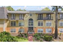 Multi-level condominium building featuring a symmetrical design and private balconies with black metal railings at 3997 Versailles Dr # 3997F, Orlando, FL 32808