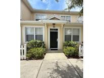 Charming townhome entrance featuring a black door, white trim, and well-maintained landscaping at 4002 San Gallo Dr # 105, Kissimmee, FL 34741