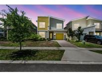 Striking two-story home with modern design, lush landscaping, and a yellow accent garage door at 4367 Rhyme St, Kissimmee, FL 34746