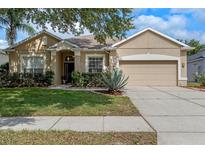 Charming single-story home with a well-manicured lawn, lush landscaping, and a two-car garage at 5226 Smokey Water Ln, Oviedo, FL 32765