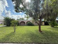 Charming home with a well-manicured lawn and mature trees, offering a serene and inviting curb appeal at 5527 Sandalwood Dr, Orlando, FL 32839