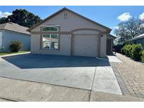 Charming single-story home with a well-maintained lawn, a two-car garage, and a welcoming entrance at 8258 Golden Chickasaw Cir, Orlando, FL 32825