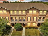 Beautiful three-story townhouse boasts a well-maintained lawn, tidy landscaping, and inviting front porches at 9997 Town Lake Dr, Orlando, FL 32832