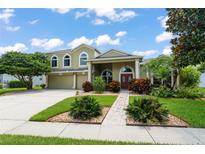 Two-story home with manicured lawn, mature trees, and paver walkway to a double front door at 10254 Hart Branch Cir, Orlando, FL 32832