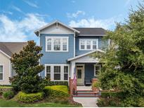 Charming two-story home with a blue exterior, white trim, and a welcoming front porch with brick accents at 1034 Huntspoint St, Winter Garden, FL 34787