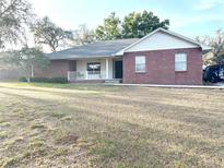 Charming single-story brick home with a welcoming front porch and well-maintained lawn at 1140 Odoniel S Loop, Lakeland, FL 33809
