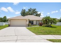 Charming single-story home featuring a well-manicured lawn, palm trees, and an attached two-car garage at 14301 Bending Branch Ct, Orlando, FL 32824