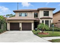 Elegant two-story home with a terracotta roof, lush landscaping, and a two-car garage in a suburban neighborhood at 1769 Turnberry Ter, Orlando, FL 32804