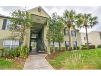 Inviting two-story building with stairs, beautiful trees and lush landscaping adds to the welcoming curb appeal at 2065 Dixie Belle Dr # O, Orlando, FL 32812