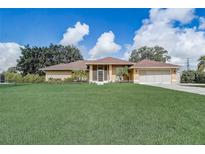 Charming single-story home featuring a spacious lawn, screened porch, and attached two-car garage at 2800 Woodsmere Ct, Kissimmee, FL 34746