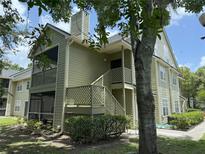 Inviting two-story condo with green siding, charming lattice accents, and a covered porch, nestled among mature trees at 3713 S Lake Orlando Pkwy # 6, Orlando, FL 32808