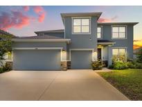 Beautiful two-story home featuring a three-car garage and manicured lawn at sunset at 5846 Sw 80Th Ln, Ocala, FL 34476