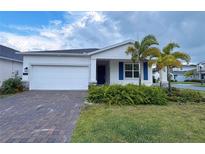 Charming single-Gathering home with a two-car garage, brick paver driveway and tropical landscaping at 6300 Chirpine Ln, St Cloud, FL 34771