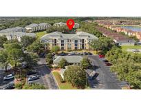 Inviting three-story apartment building with well-maintained landscaping and ample parking spaces for residents and guests at 8816 Dunes Ct # 303, Kissimmee, FL 34747
