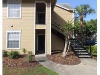 Inviting apartment complex featuring stairs leading to the second floor entrance with a small palm tree at 1019 S Hiawassee Rd # 3811, Orlando, FL 32835