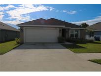 Charming single-story home featuring a well-maintained lawn and attached two-car garage at 1105 Citrus Landings Blvd, Davenport, FL 33837
