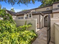 Charming home exterior with manicured landscaping and a private gated entrance to the front door at 1547 Farrindon Cir # 1547, Lake Mary, FL 32746