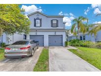 Light blue two story home featuring attached two car garages, concrete driveway and manicured front lawn at 20610 Maxim Pkwy, Orlando, FL 32833