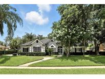 Charming single-story home with a well-manicured lawn, lush landscaping, and a welcoming front entrance at 2890 Wild Ginger Ct, Winter Park, FL 32792