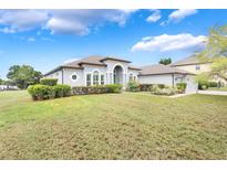 Stunning single-story home with a well-manicured lawn and beautiful landscaping on a sunny day at 3531 Oriskany Dr, Orlando, FL 32820