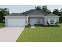 Charming single-story home features a two-car garage, well-manicured lawn and simple, colorful landscaping at 5381 Sw 128Th Street Rd, Ocala, FL 34473