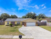 Charming single-story home with a well-manicured lawn and a two-car garage at 7750 Murcott Cir, Orlando, FL 32835