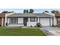 Charming single-story home with a well-maintained lawn, painted in white with gray trim, a single car garage and nice landscaping at 1184 Calanda Ave, Orlando, FL 32807