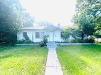 Charming single-story home with green lawn, trees and inviting pathway to the front door at 1403 N Fern Creek Ave, Orlando, FL 32803