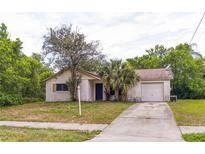 Charming single-story home featuring an attached garage and mature landscaping in the front yard at 1421 Summit Hill Dr, Deltona, FL 32725