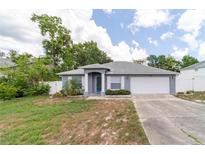 Charming single-story home featuring a two-car garage and well-maintained landscaping in a serene neighborhood at 1530 Monica St, Deltona, FL 32725
