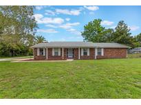 Charming single-story brick home with well-maintained lawn and mature trees providing shade at 247 Carmen Ln, Debary, FL 32713