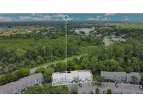 Birds eye view of townhomes surrounded by lush greenery and a scenic lake in the distance at 4443 Brook Hollow Cir # 19A, Winter Springs, FL 32708