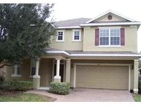 Inviting two-story home boasts a brick driveway, an attached two-car garage and neutral siding at 544 Legacy Park Dr, Casselberry, FL 32707