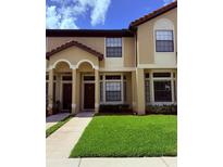 Attractive two-story townhome featuring manicured lawn and charming architectural details at 6013 Scotchwood Gln # 20, Orlando, FL 32822