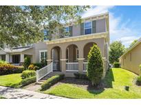 Charming two-story home featuring a welcoming front porch and professionally landscaped front yard at 7816 Winter Wren St, Winter Garden, FL 34787