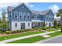 Charming two-story blue and white home featuring a well-manicured lawn and inviting front porch at 8427 Modiano St, Orlando, FL 32827