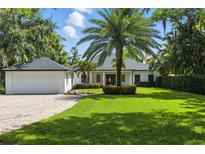 Charming single-story home with lush landscaping, brick driveway, and a spacious two-car garage at 10209 Trout Rd, Orlando, FL 32836