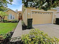 Charming home with a two-car garage, landscaped front yard, and inviting entryway at 109 Greentree Ln, Yalaha, FL 34797