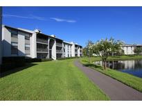 Apartment complex with well-maintained landscaping, walkway and pond at 1131 S Pine Ridge Cir # 1, Sanford, FL 32773