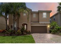 Charming two-story home with a brick driveway, well-manicured lawn and beautiful landscaping at 12286 Regal Lily Ln, Orlando, FL 32827