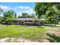 Charming single-story home featuring a spacious front yard and a covered carport at 1250 Tangerine Ct, Eustis, FL 32726