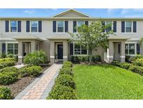 Charming townhome featuring a brick walkway, manicured lawn, and inviting entrance at 13293 Pontoon Rd, Winter Garden, FL 34787