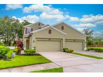 Charming two-story home featuring a three-car garage and well-maintained landscaping under a blue sky at 1356 Scarlet Oak Loop, Winter Garden, FL 34787