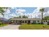 Charming single story home with a car port and lovely landscaping on a sunny day at 1801 Palm Ln, Orlando, FL 32803