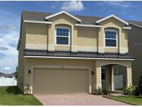Inviting two-story home featuring a two-car garage, arched entry, tan stucco, and a well-maintained lawn at 1855 Church Lake St, Groveland, FL 34736
